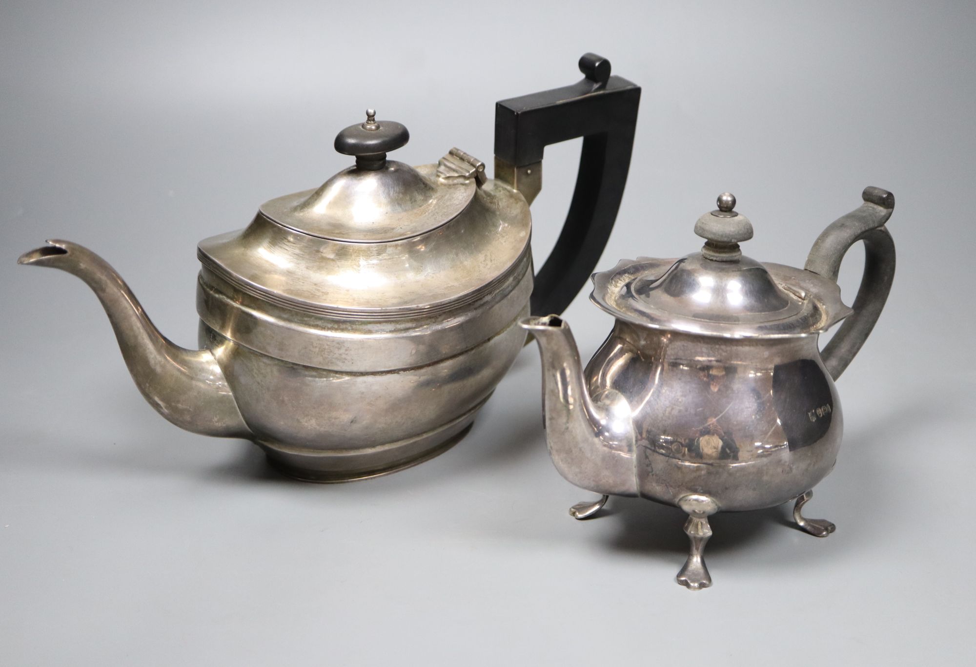 A George V silver London shape teapot and an earlier small circular form teapot with shaped rim, gross 32oz.
